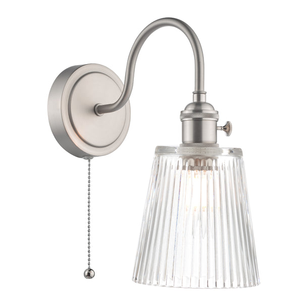 Brushed nickel wall sconce with a curved arm, ribbed clear glass shade, and a pull chain switch.