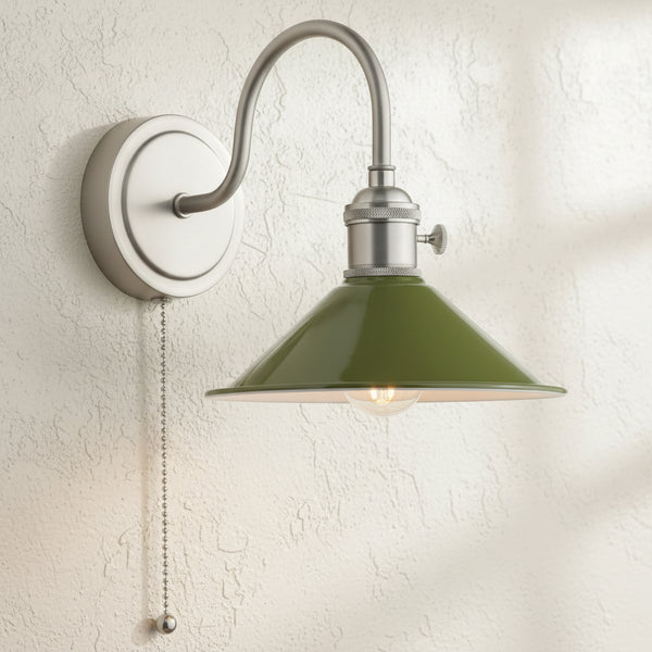Brushed nickel wall sconce with a curved arm, a green conical shade, and a pull chain switch. It has an exposed Edison bulb.