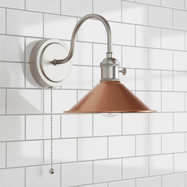 Brushed nickel wall sconce with a curved arm and a rust-colored, cone-shaped shade. A pull chain hangs below.