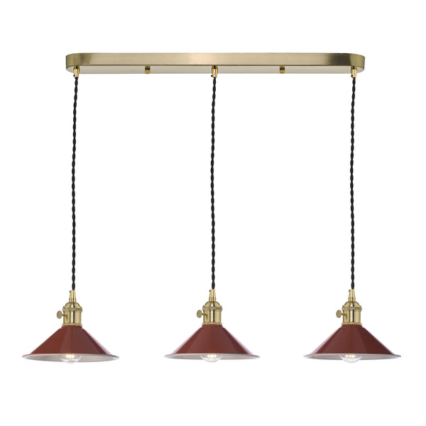 Three pendant lights with rust-colored shades and brass fittings hang from a gold bar.