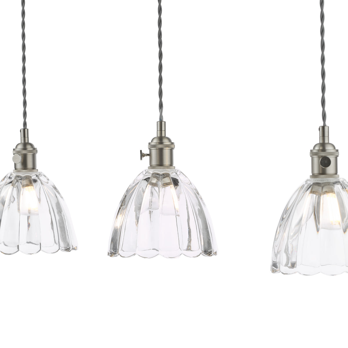 Three clear glass pendant lights with fluted shades and brushed metal fittings, hanging from twisted grey cords.