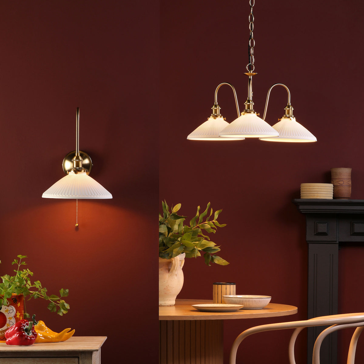 A wall sconce and a three-light chandelier with pleated white shades and brass accents.