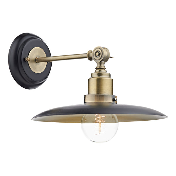 Industrial-style wall sconce with a black circular base, brass arm, and a black metal shade over a clear bulb.
