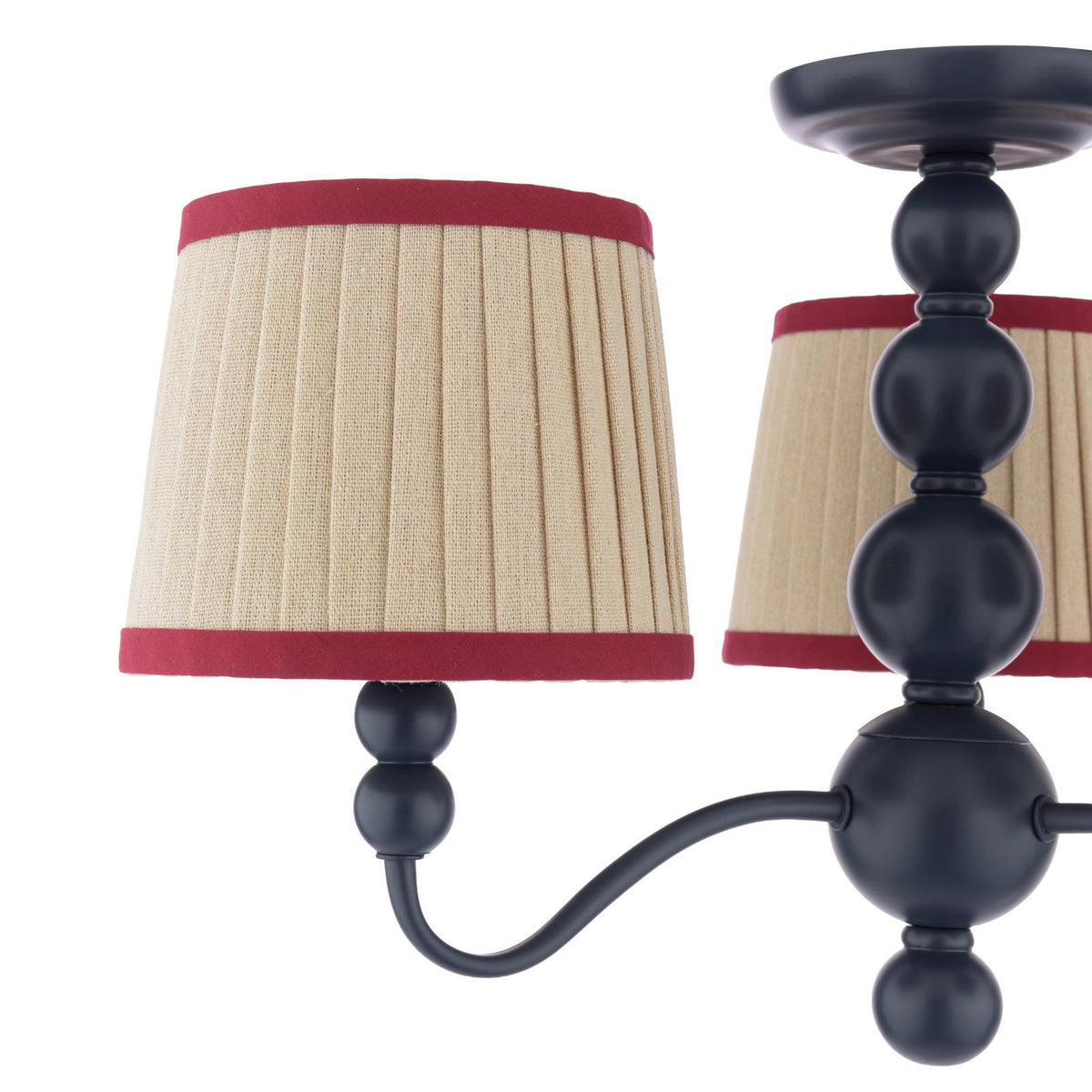 Black metal chandelier with beige pleated fabric shades and red trim