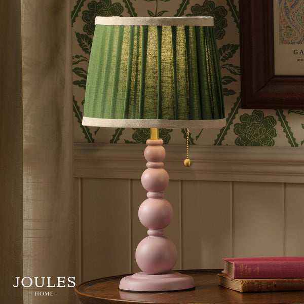 Joules Harewood table lamp with a matt pink stacked sphere base and a green pleated linen shade