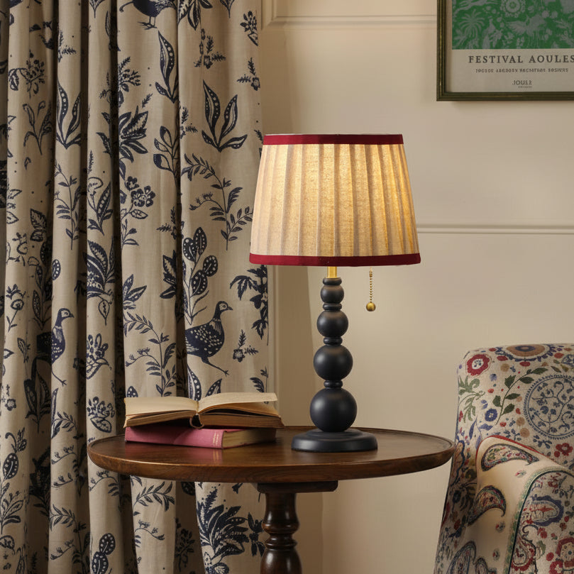 Joules Harewood table lamp in matt blue with a pleated linen shade on a wooden side table
