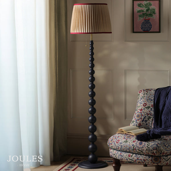Joules Home floor lamp with a dark blue beaded stand and a pleated beige lampshade with red trim