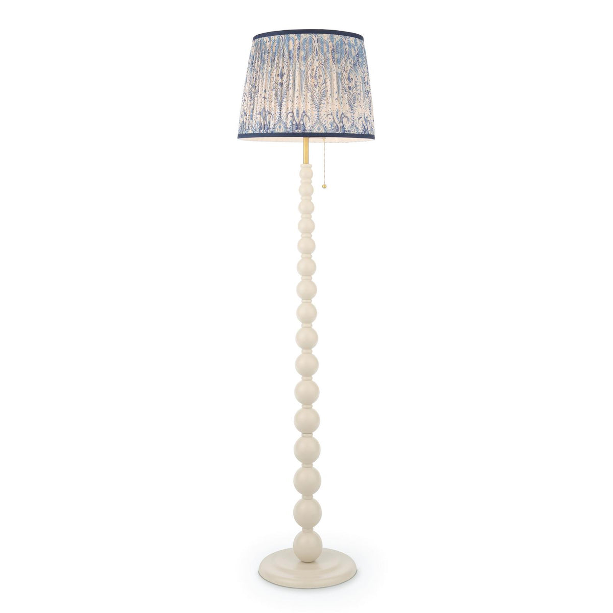 Cream floor lamp with a stacked ball base and a blue and white patterned fabric drum shade