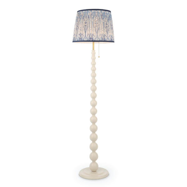 Cream floor lamp with a stacked ball base and a blue and white patterned fabric drum shade