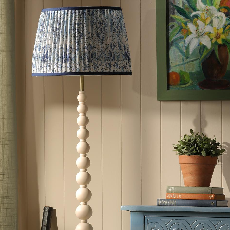 Floor lamp with white stacked sphere base and blue and white patterned pleated shade