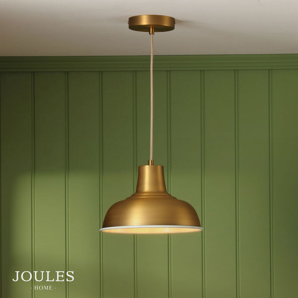 Joules Home brass dome pendant light hanging against a green paneled wall