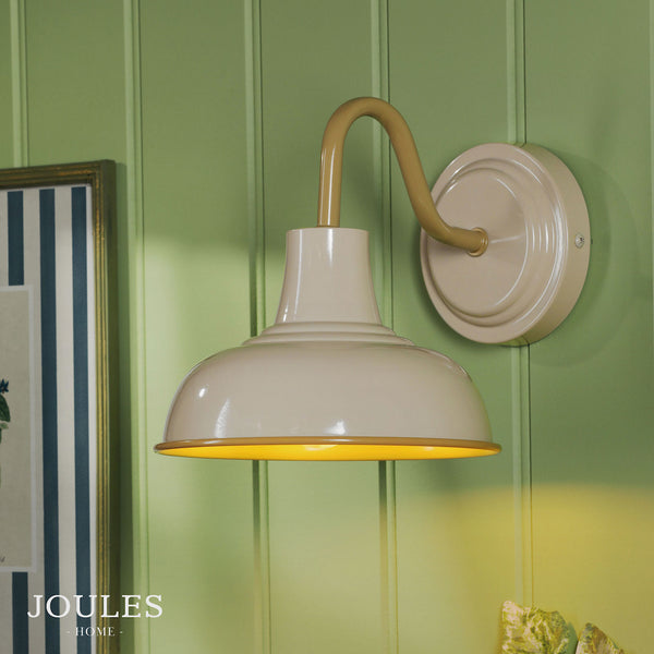 Joules Home cream and gold metal wall light mounted on a green paneled wall