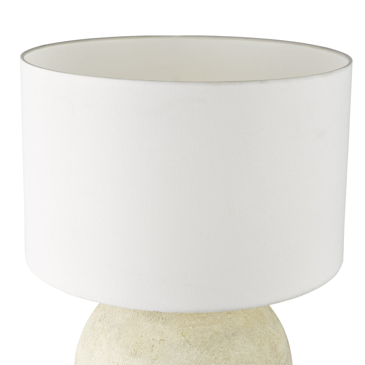 White drum lampshade on a textured beige lamp base