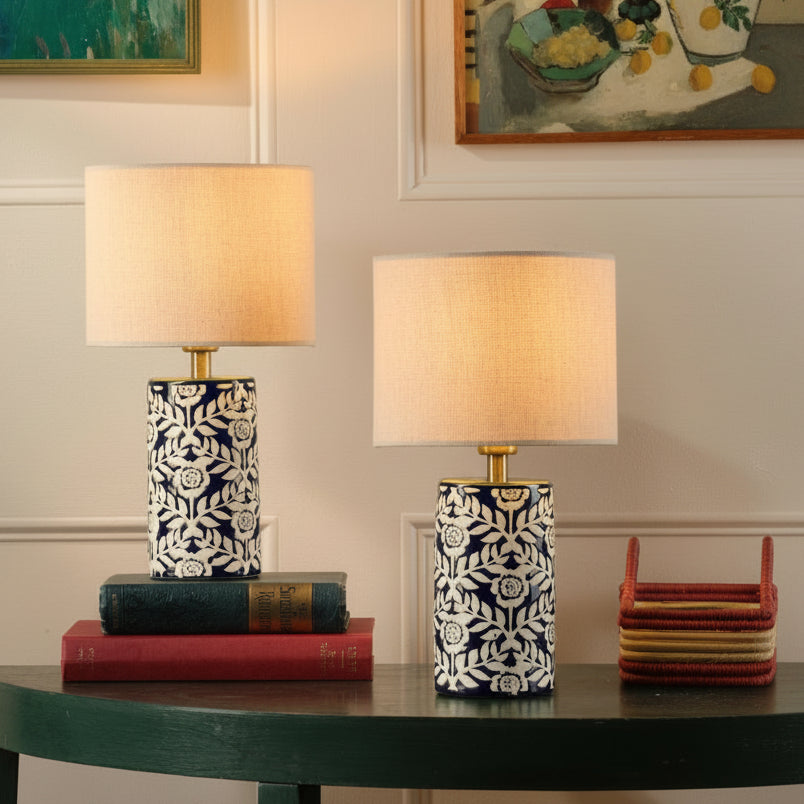 Two cylindrical table lamps with blue and white floral ceramic bases and beige fabric drum shades