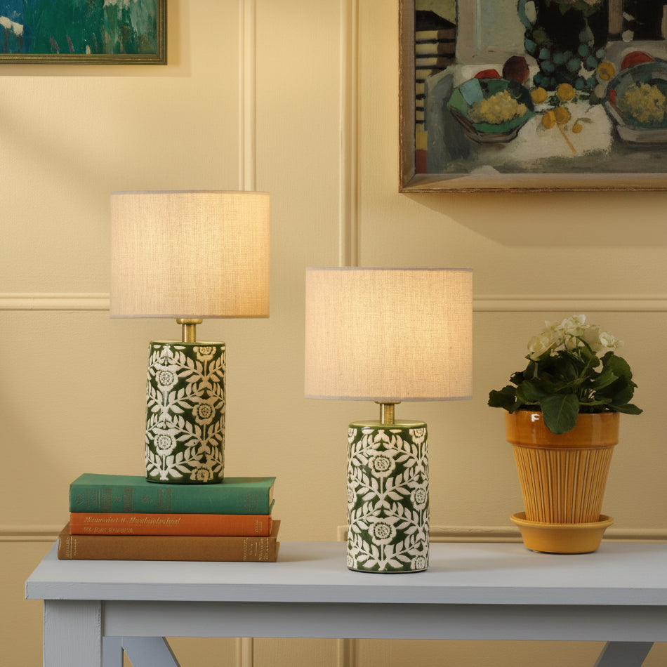 Joules twin pack of small Highclere ceramic table lamps in green with cream linen shades on a table