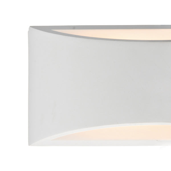 Close-up of a white, curved wall sconce with warm light emanating from the top and bottom.