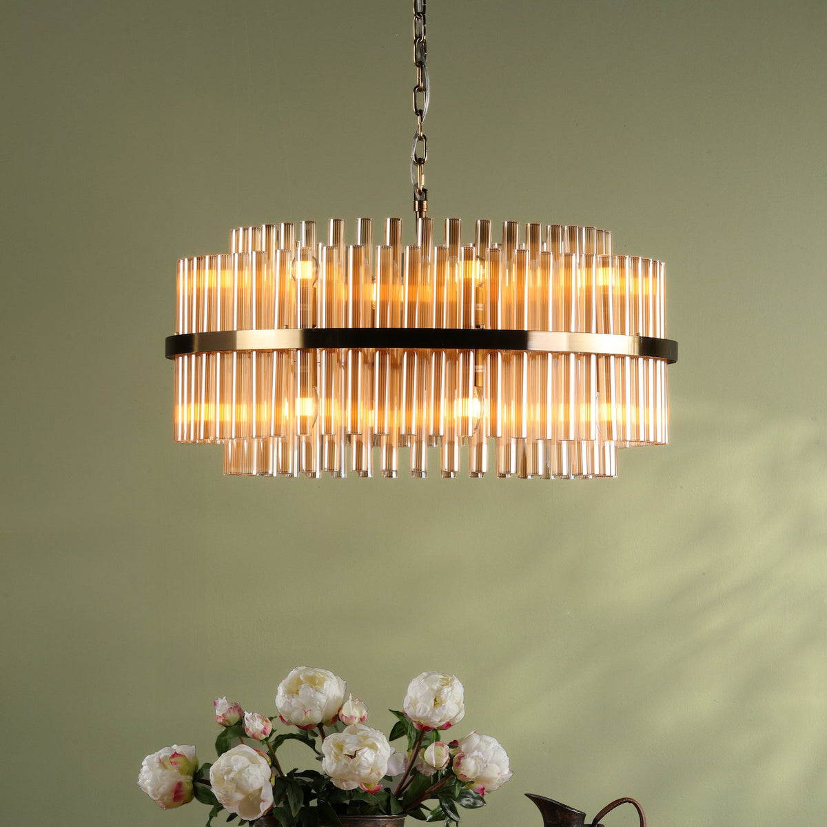 Round chandelier with amber glass rods and a gold-finished frame