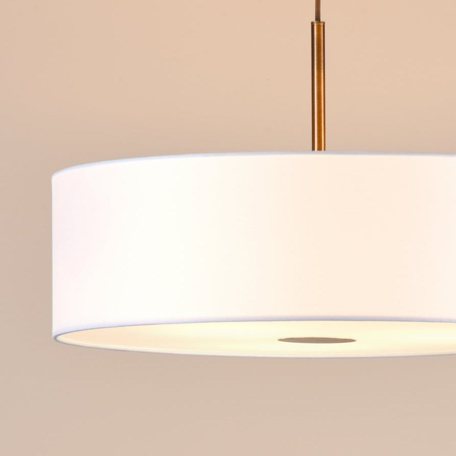 White drum pendant light with a brass finish stem