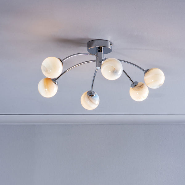 Modern ceiling light with six spherical, marbled glass shades on chrome arms.