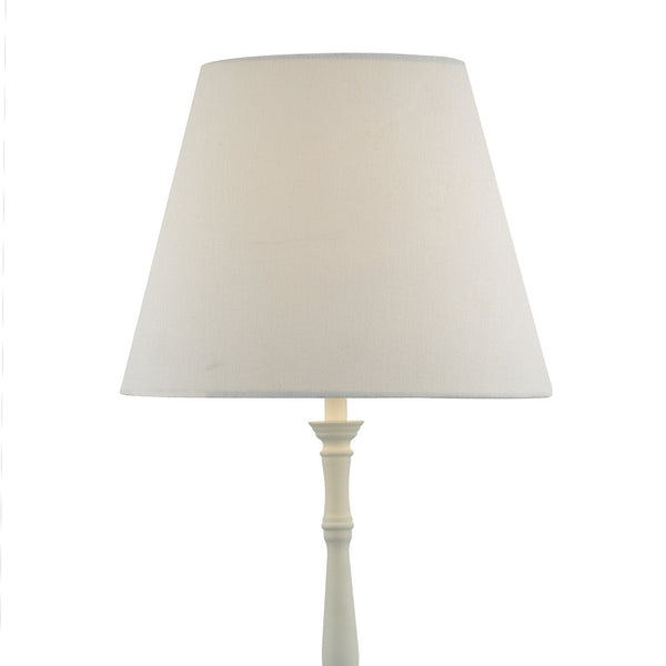 White lamp with a conical fabric shade and a carved base.