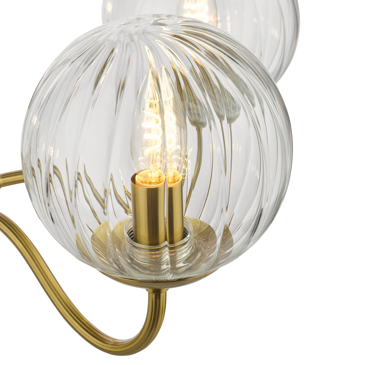 Close up of a clear glass globe light fixture with a ribbed texture and a brass base