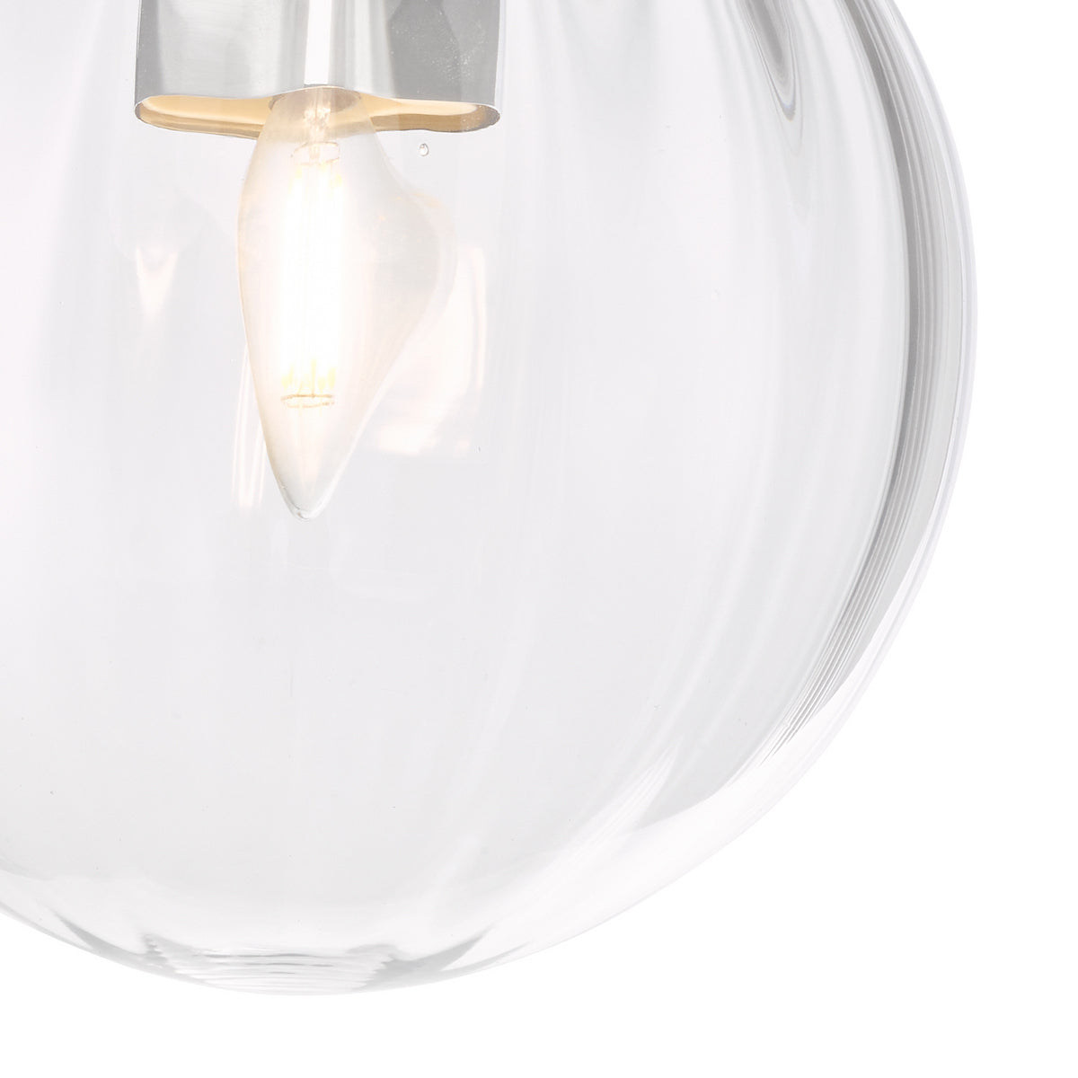 Close-up of a clear glass pendant light with a glowing bulb inside.