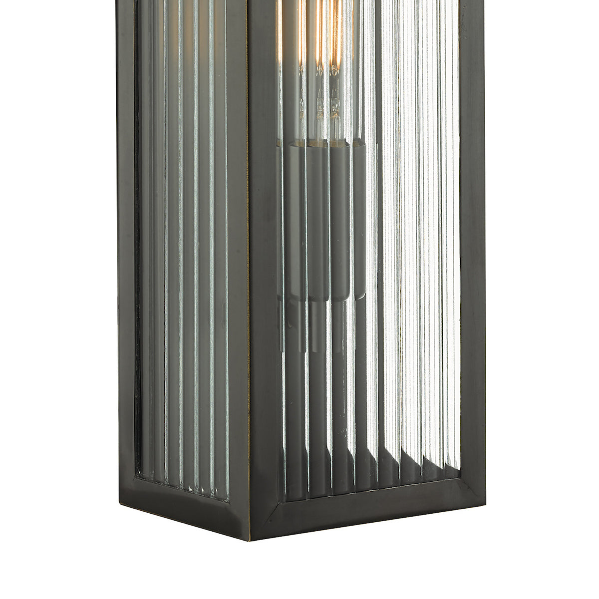 Close up of a rectangular outdoor wall light with fluted glass and a visible filament bulb