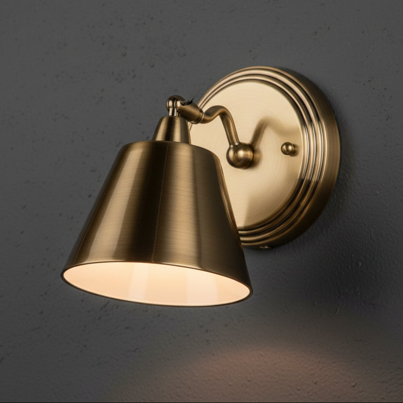 Brass wall light with a conical shade and a round base