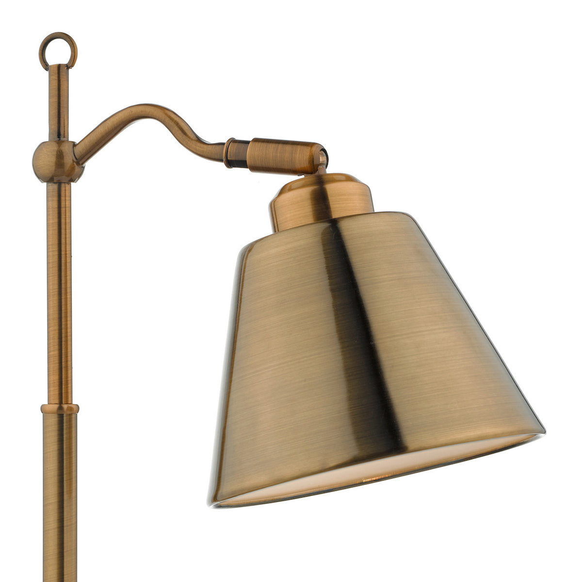 Close up of a brushed brass floor lamp with a conical shade