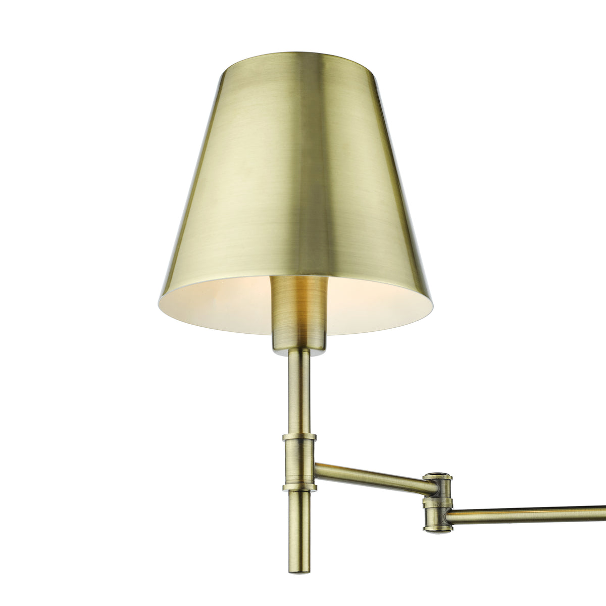 Close up of a brass wall lamp with a conical shade and an adjustable arm
