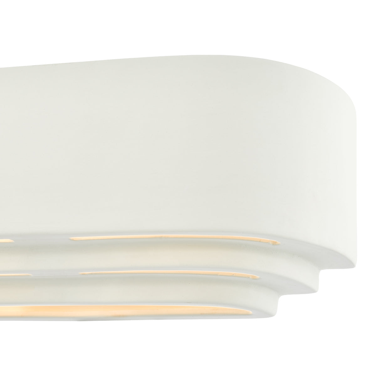 Close-up of a white, curved wall sconce with three horizontal light slits emitting a warm glow.