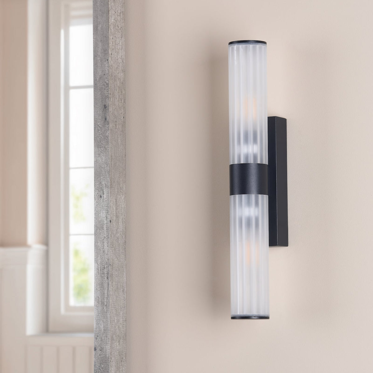 Black and white cylindrical wall sconce with ribbed glass shade