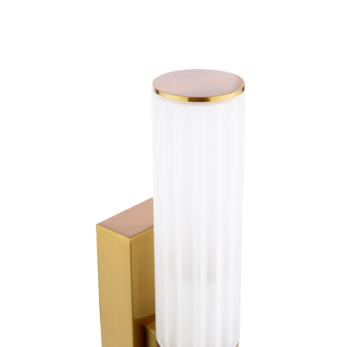 Close up of a brass wall sconce with a cylindrical ribbed glass shade and a brass top