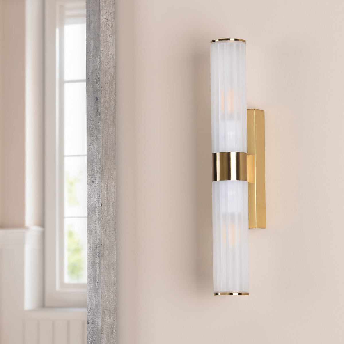 Vertical brass wall sconce with two ribbed frosted glass shades