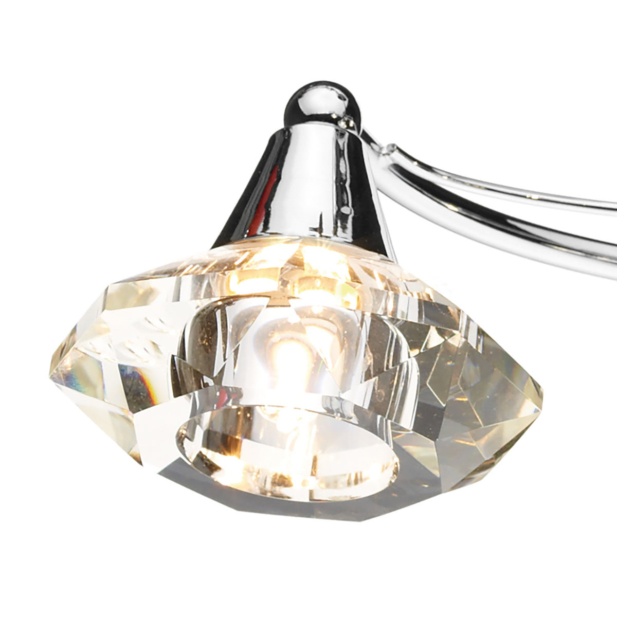 Close-up of a faceted crystal light fixture with a chrome base and a glowing bulb inside.