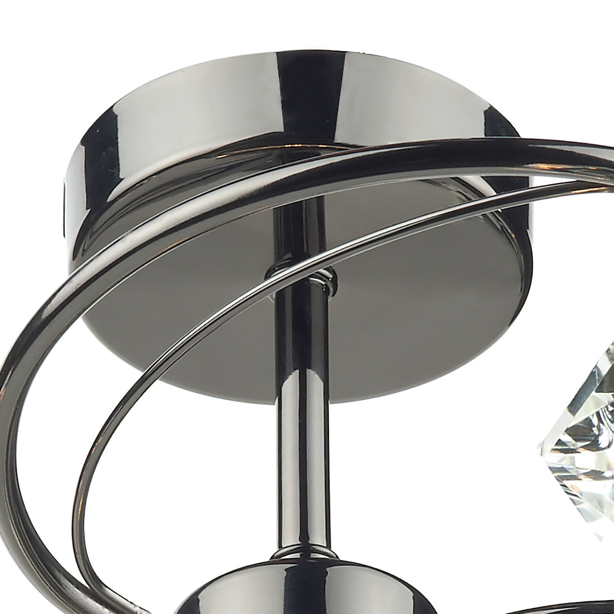 Close-up of a polished chrome light fixture with curved arms and a clear crystal accent.