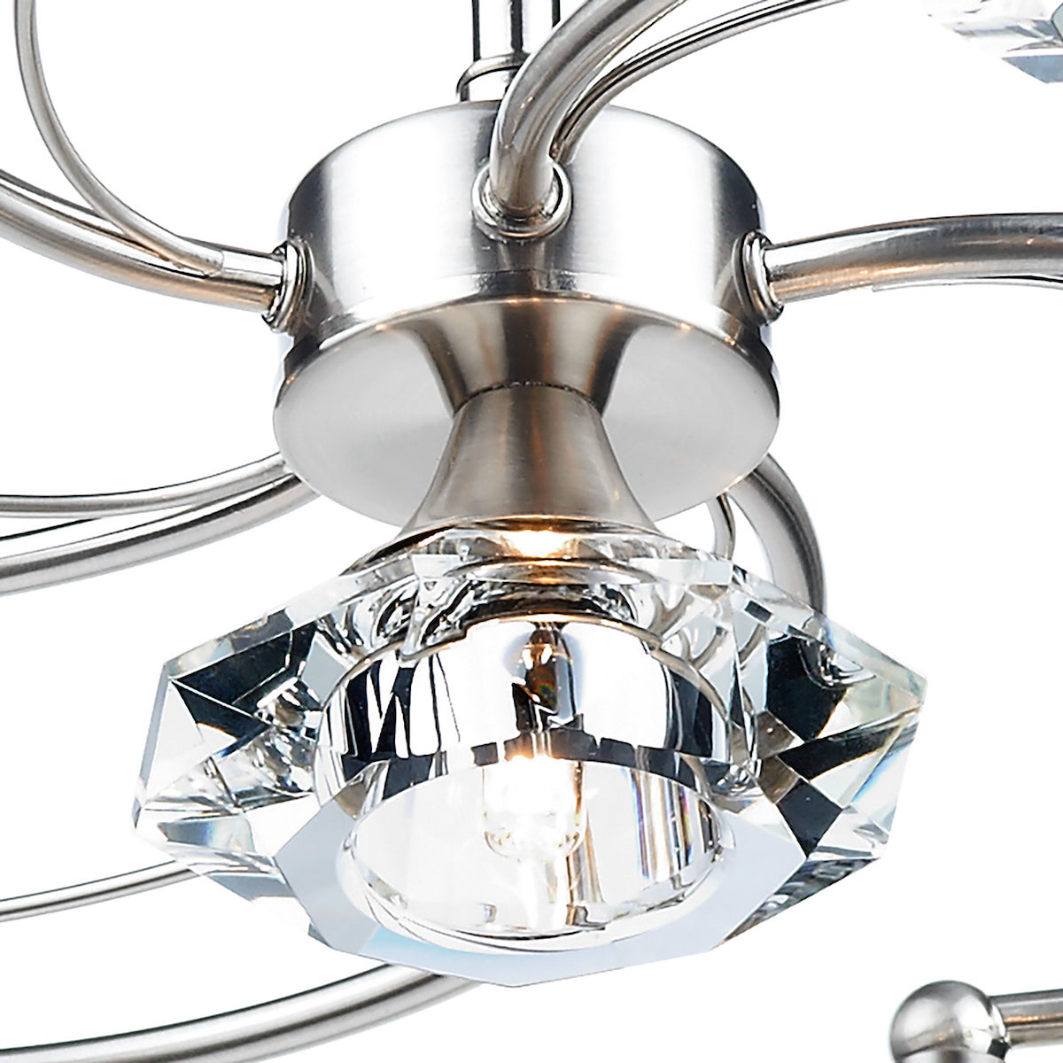 Close-up of a brushed nickel light fixture with a faceted crystal shade and glowing bulb.