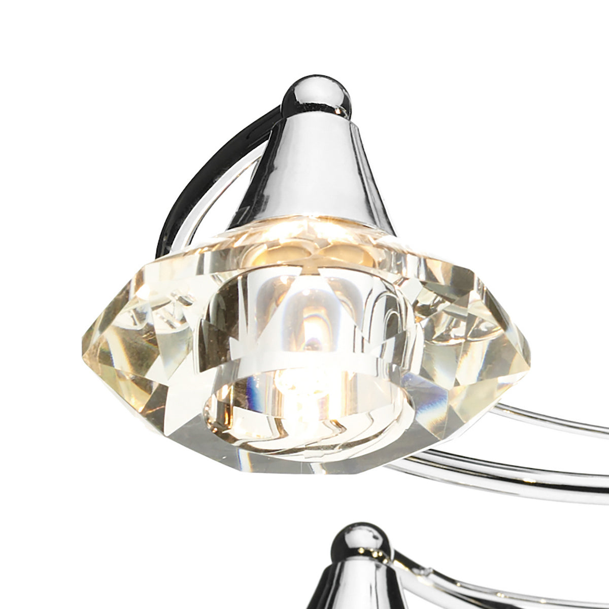 Close-up of a crystal light fixture with a chrome base and a glowing bulb.