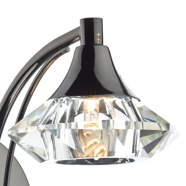 Close-up of a black and chrome light fixture with a faceted clear glass shade.