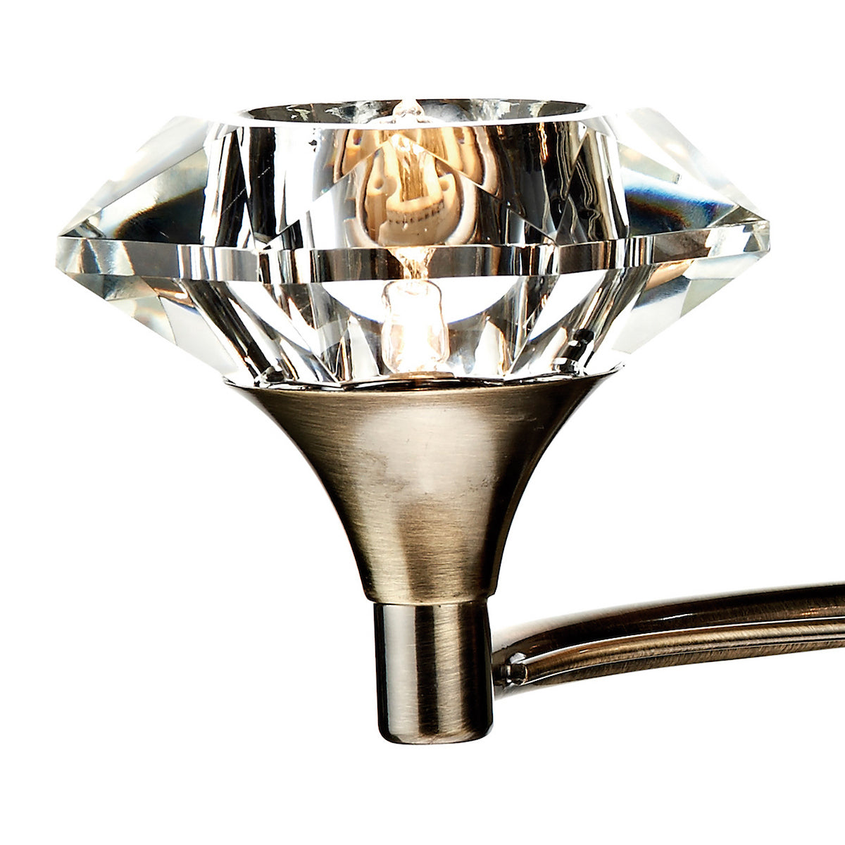 Close-up of a crystal light fixture with a diamond-shaped shade and a bronze base.