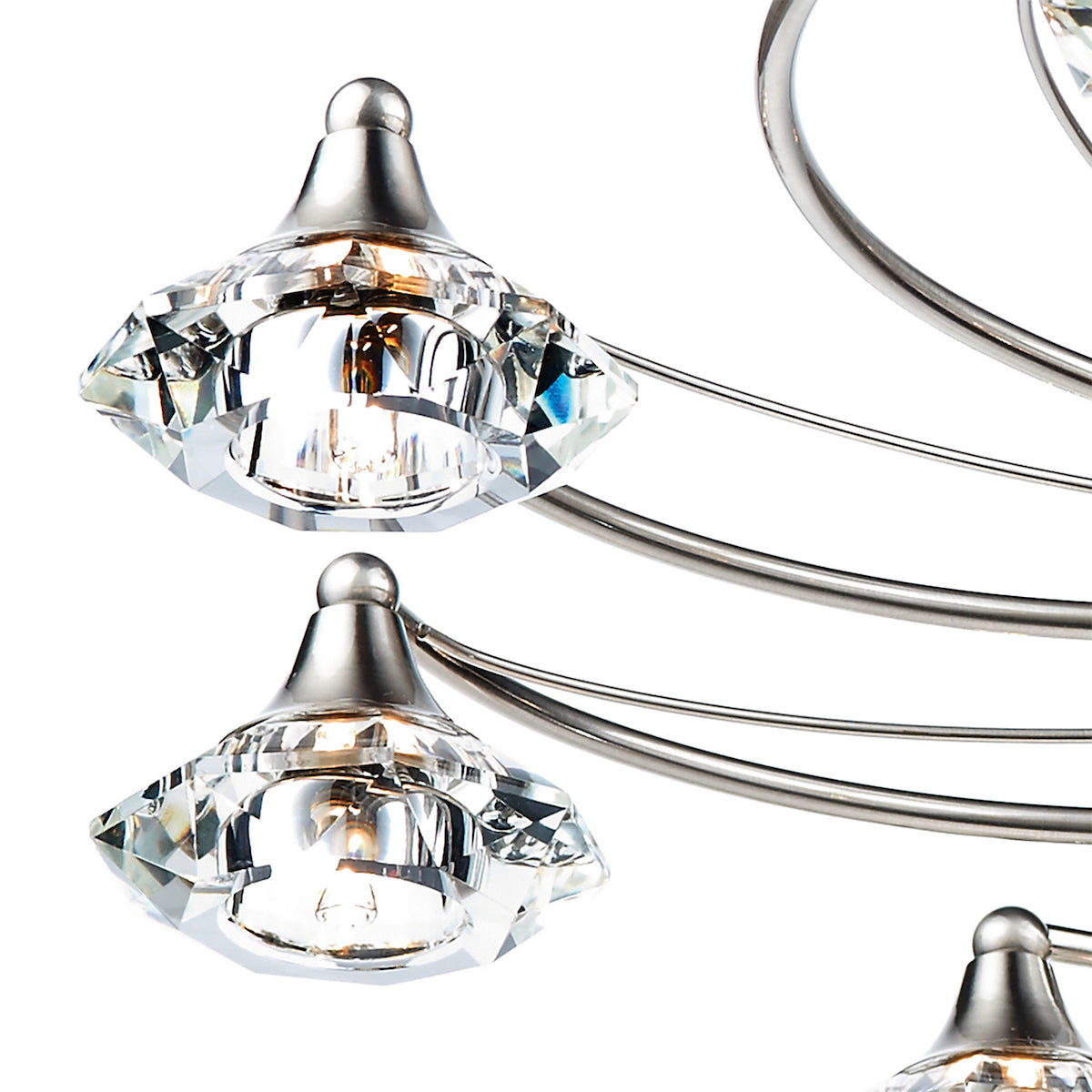 Close-up of a modern chandelier with brushed nickel arms and faceted crystal shades.