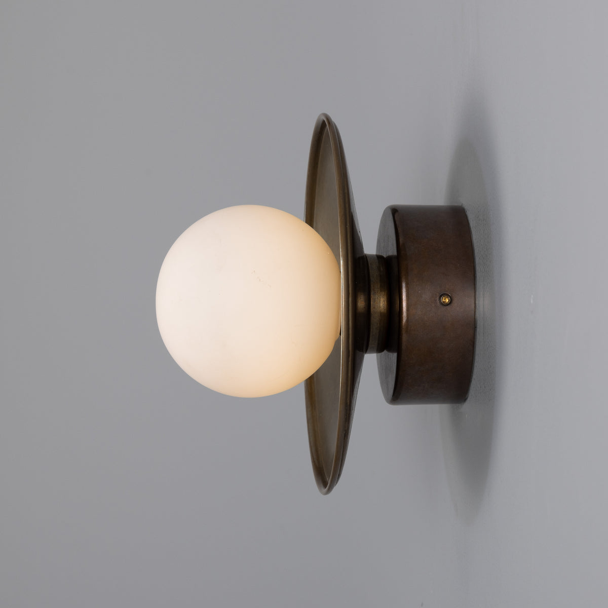 Aosta IP65 Brass Disc Bathroom Wall Light in Antique Brass with Opal Glass Globe
