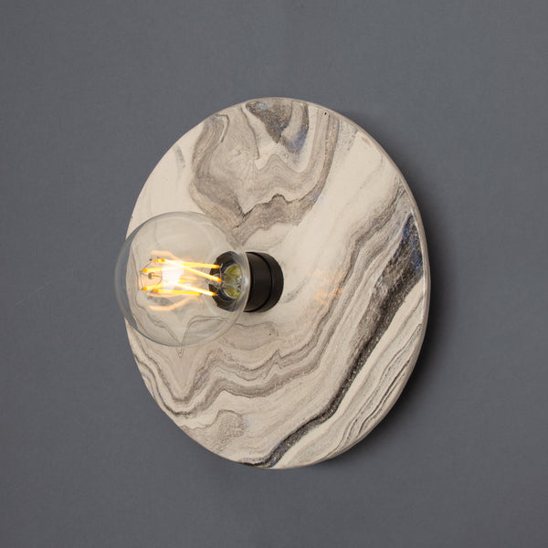 Mullan Bog Oak marbled ceramic disc wall light with matte black detail and exposed filament bulb