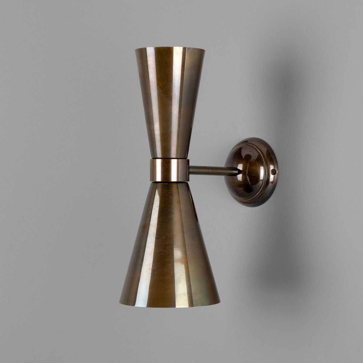 Double cone wall sconce in antique brass finish