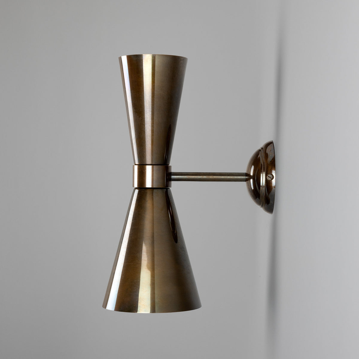 Double cone wall sconce in antique brass finish