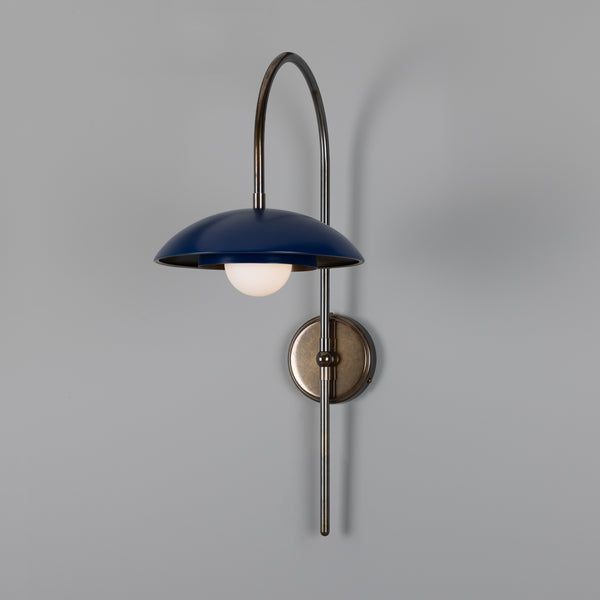 Blue dome wall sconce with a curved metal arm and round backplate