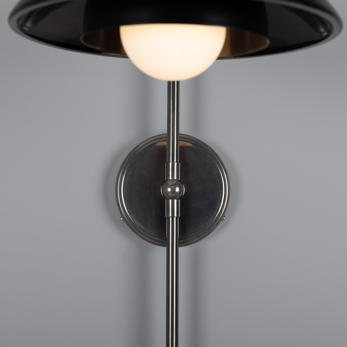 Black and brushed nickel wall sconce with a round glass globe shade