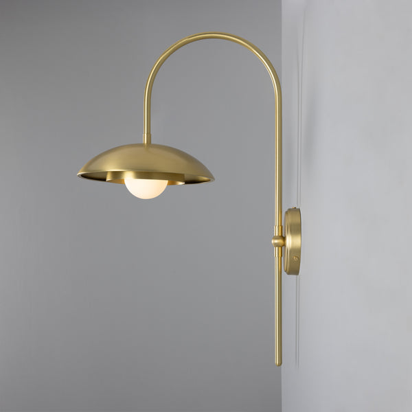 Mullan Marrakesh Art Deco arc wall light in satin brass with a dome shade and glowing bulb