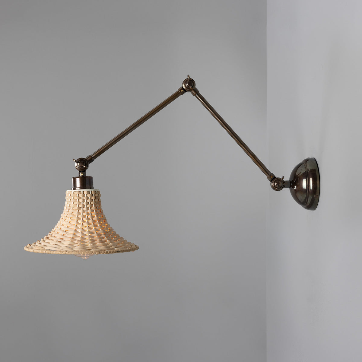 Savannah Adjustable Arm Wall Light in Antique Brass with Small Bell Shaped Rattan Shade