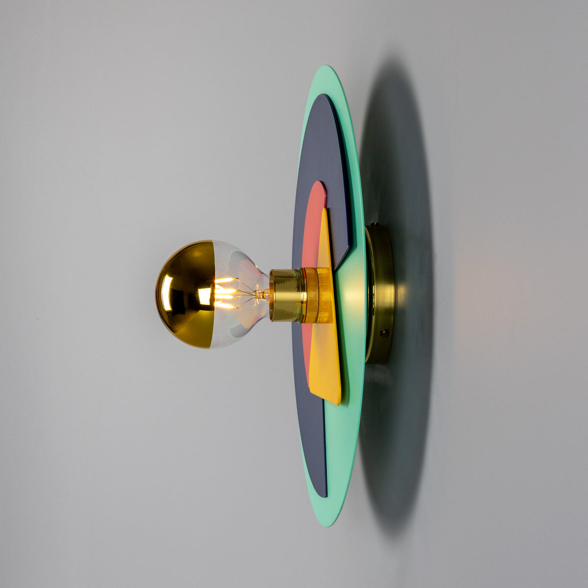 Mullan Earth colourful disc wall light in polished brass with layered geometric shapes and a half gold bulb